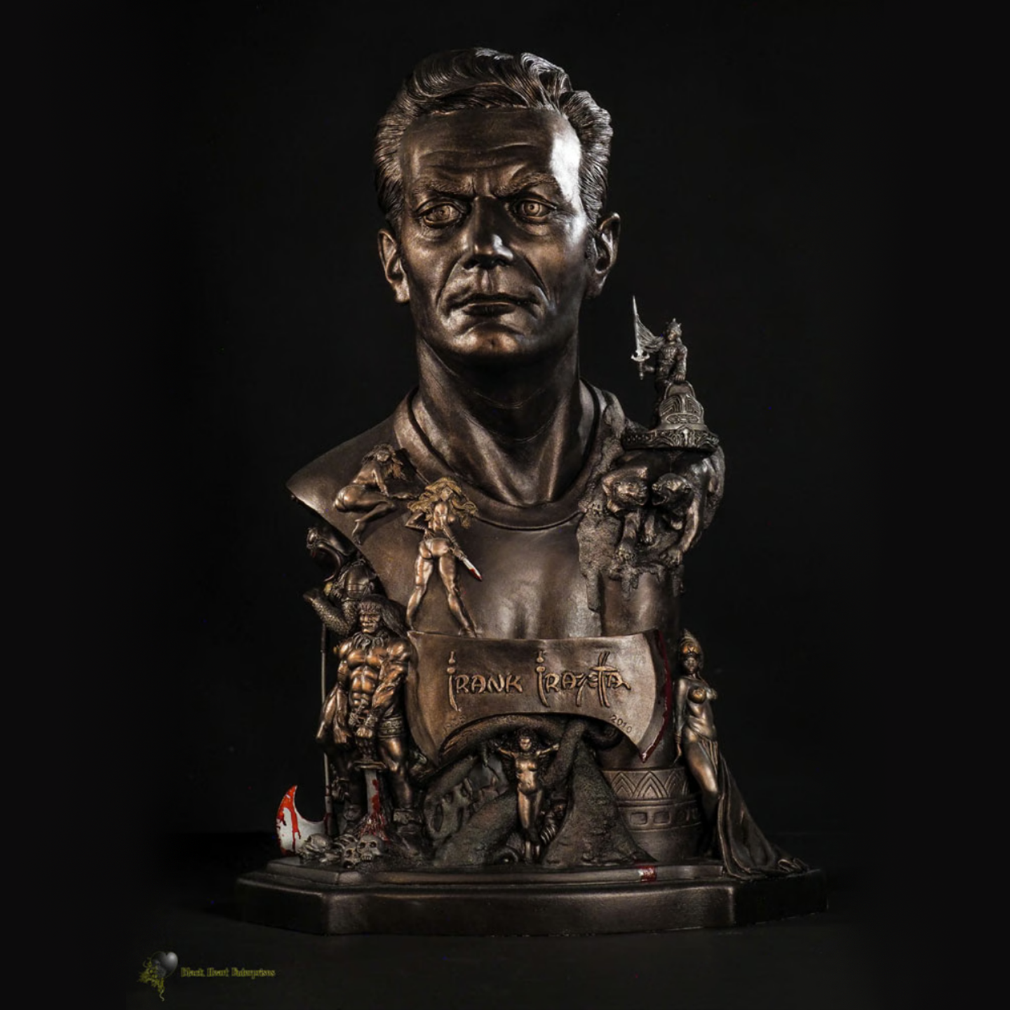 A highly detailed faux bronze polystone bust of Frank Frazetta, featuring his likeness surrounded by intricate bas-relief sculptures of his iconic fantasy characters, including Death Dealer, Conan, and other legendary figures. The name "Frank Frazetta" is displayed on a plaque integrated into the design, emphasizing his artistic legacy. The sculpture is set against a dark background, highlighting its dramatic and museum-quality craftsmanship.