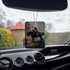 Frazetta Death Dealer I air freshener hanging in a car with black interior. The Frazetta Art Museum sits in the background with gloomy clouds overhead.