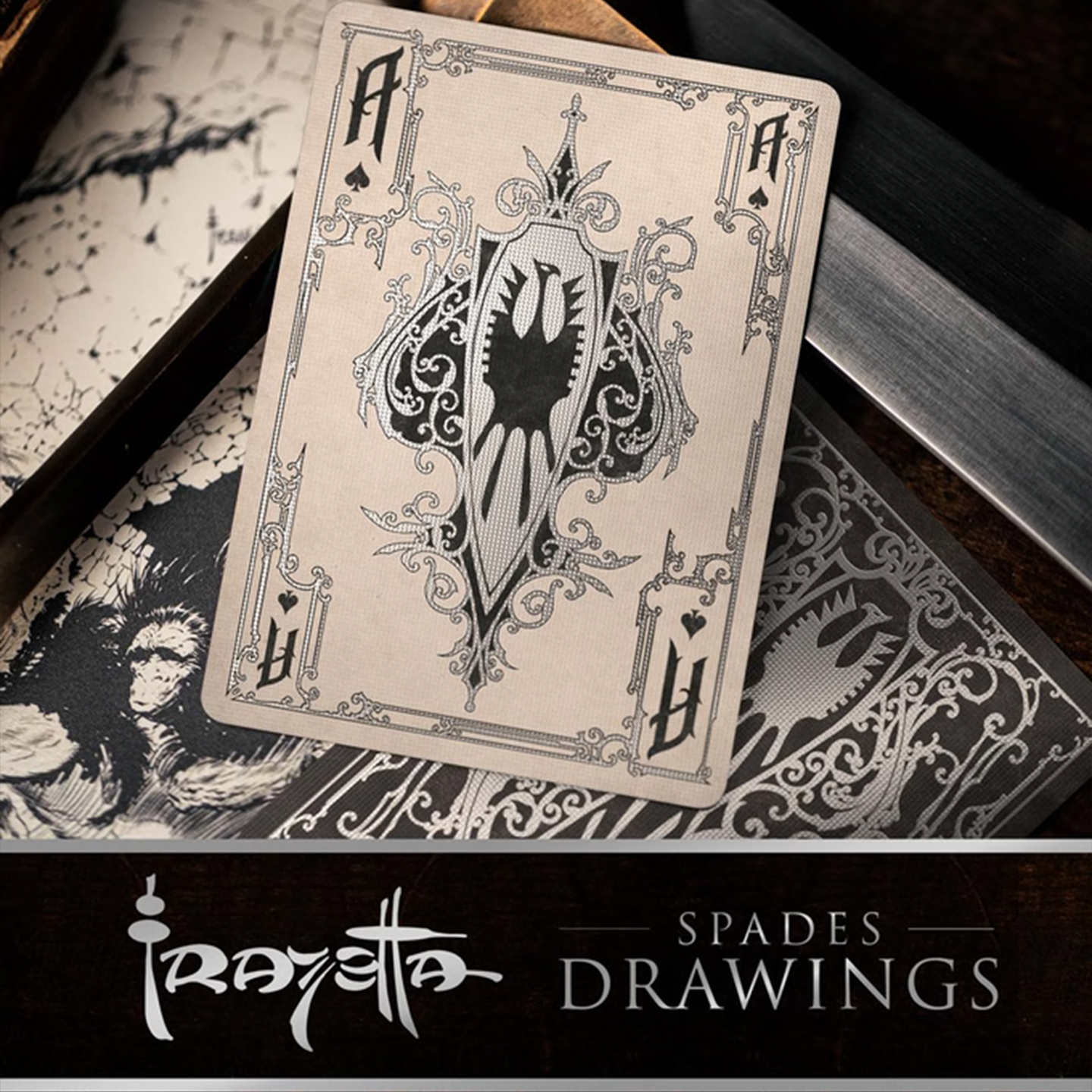 A close-up of an Ace of Spades from the Frazetta Drawings Edition playing card deck. The card features an ornate, vintage-style border with delicate filigree and a stylized club symbol at its center. Beneath it, additional cards are partially visible, showcasing intricate artwork and embossed detailing. A knife rests nearby, enhancing the dramatic composition.
