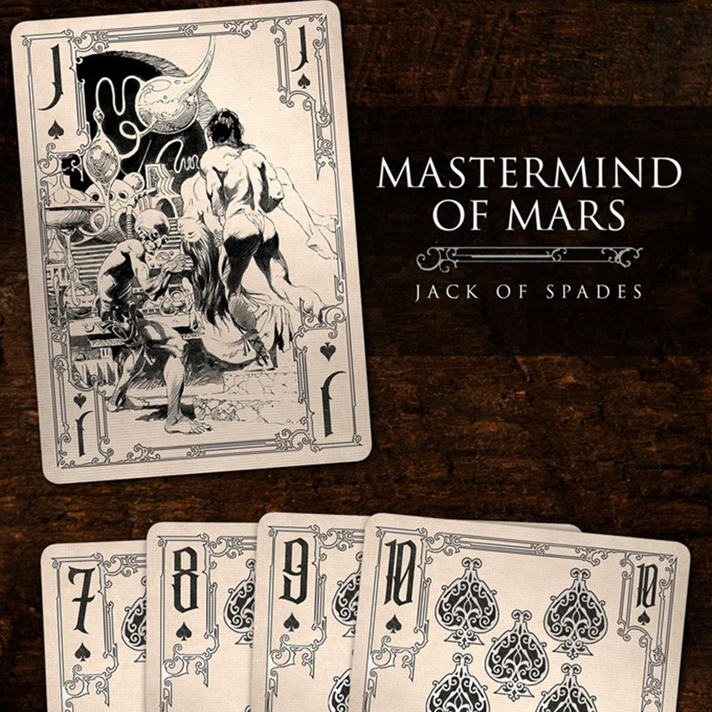 A close-up of a Jack of Spades from the Frazetta Drawings Edition playing card deck. The card features an iconic Frazetta drawing with an ornate, vintage-style border with delicate filigree. Beneath it, additional cards are partially visible, showcasing intricate artwork and embossed detailing.