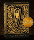 A luxurious black and gold playing card box featuring an intricate, ornate design. The front showcases a bold shield emblem with a stylized eagle at its center, surrounded by elegant filigree patterns. The box is set against a dark, textured wooden background, emphasizing its premium craftsmanship and collectible nature.