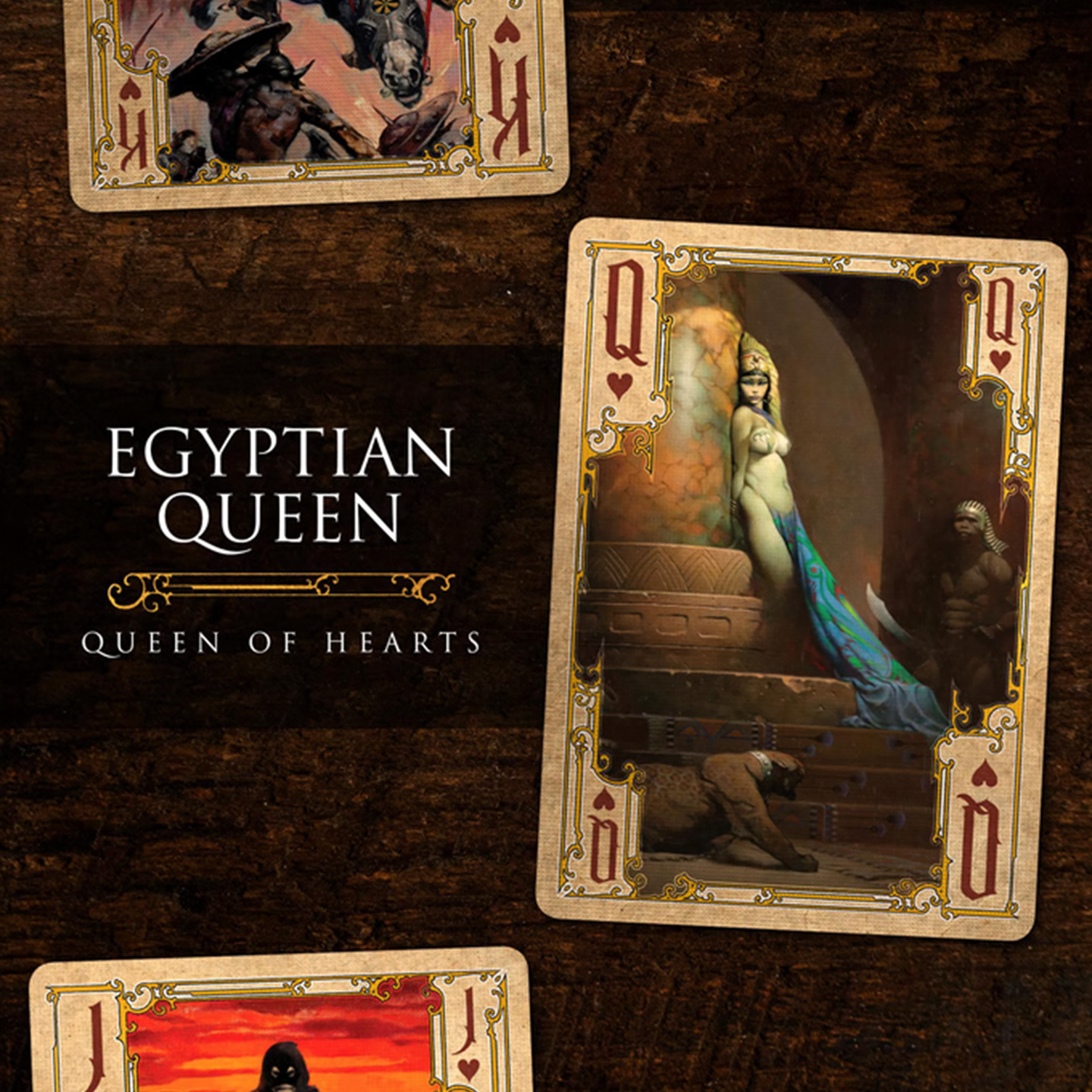 A close-up of a Queen of Hearts from the Frazetta Paintings Edition playing card deck. The card features an iconic Frazetta drawing with an ornate, vintage-style border with delicate filigree. Beneath it, additional cards are partially visible, showcasing intricate artwork and embossed detailing.
