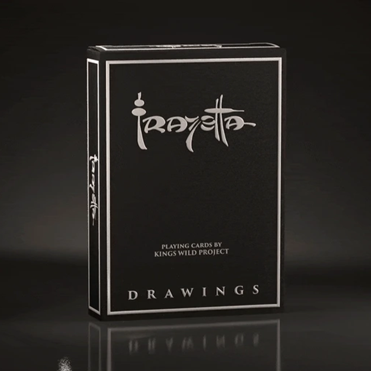 A high-end playing card deck from the Frazetta Drawings Edition is displayed against a sleek, dark background. The side of the box is adorned with the Frazetta signature, enhancing its luxury and collector’s appeal. The reflective silver details catch the light, emphasizing the deck’s premium craftsmanship.