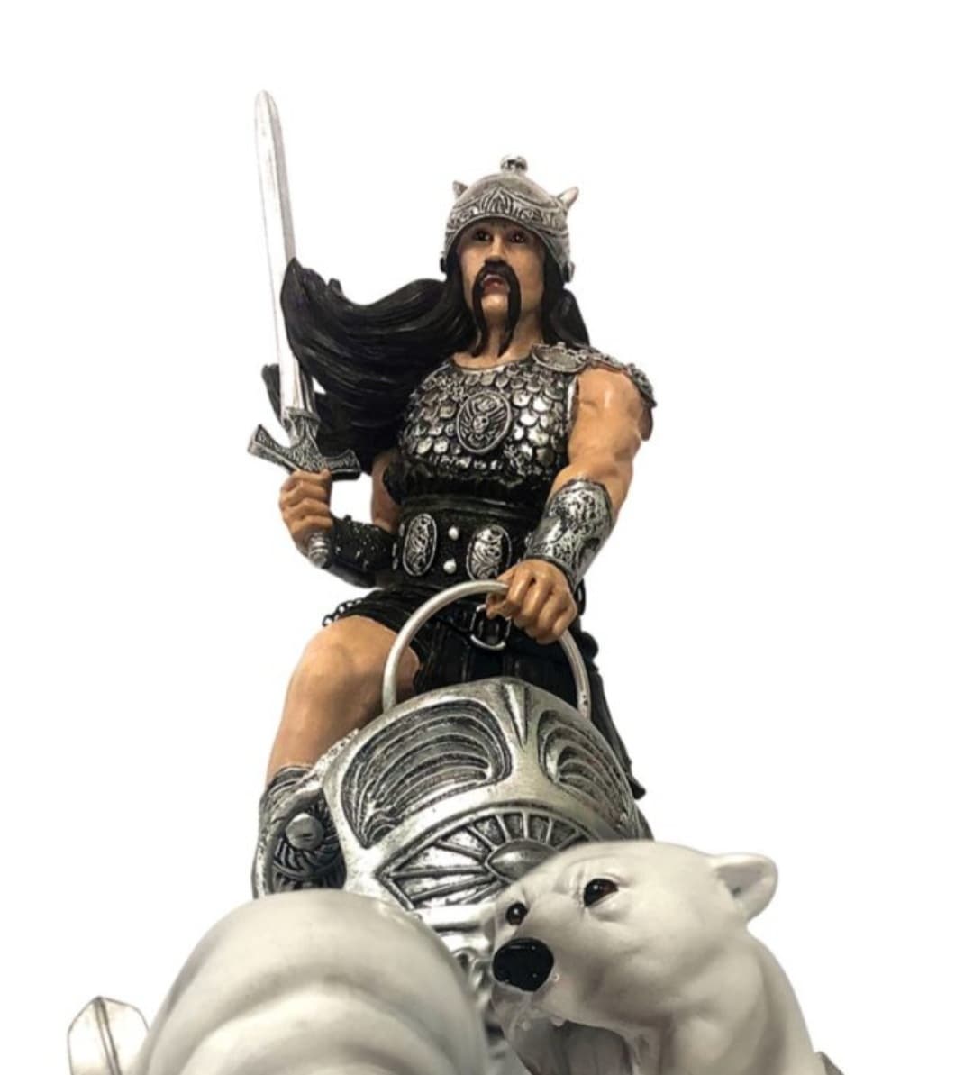 A close-up of the Ice Warrior sculpture, featuring a fierce warrior clad in detailed silver armor, gripping the reins of his chariot while holding a sword. His long black hair flows behind him, and he wears a horned helmet. In the foreground, two snarling polar bears lead the charge, showcasing the power and intensity of Frank Frazetta’s fantasy art.