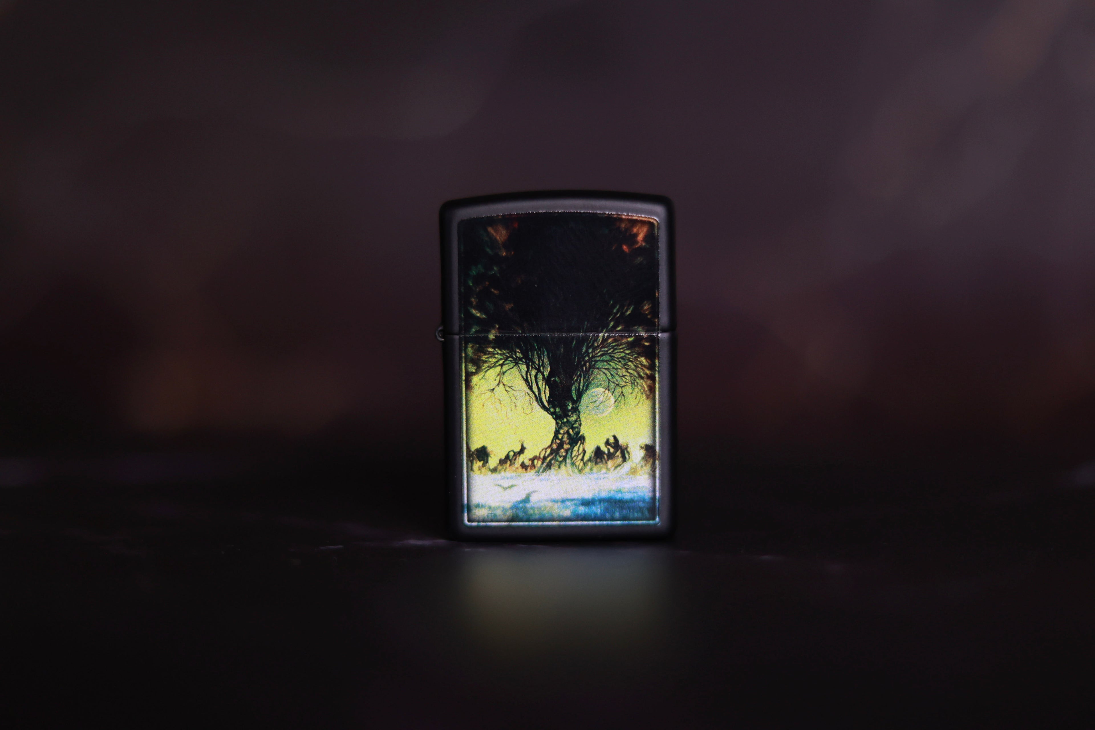 Zippo lighter with Frazetta’s “The Autumn People” painting, silhouetted figures beneath a gnarled, leafless tree under a pale yellow sky and rising moon.