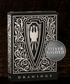 A luxurious black and silver playing card box featuring an intricate, ornate design. The front showcases a bold shield emblem with a stylized eagle at its center, surrounded by elegant filigree patterns. The box is set against a dark, textured wooden background, emphasizing its premium craftsmanship and collectible nature.