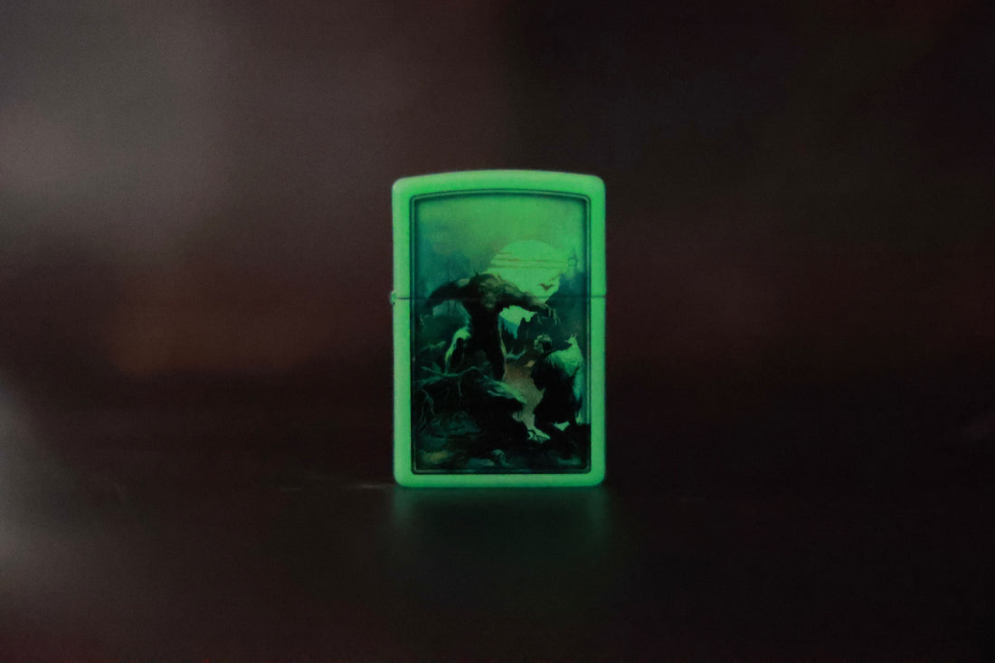 Same Wolfmoon Zippo-style lighter shown glowing in the dark, with the eerie green illumination highlighting the werewolf scene under the moonlight.