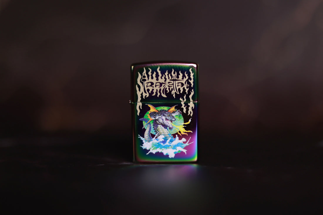 Zippo lighter featuring Frank Frazetta’s flying alligator artwork, with a colorful dragon-like creature soaring above clouds beneath a stylized Frazetta logo.